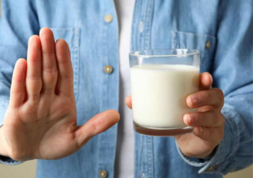 persona con intolerancia a la lactosa sujetando un vaso de leche